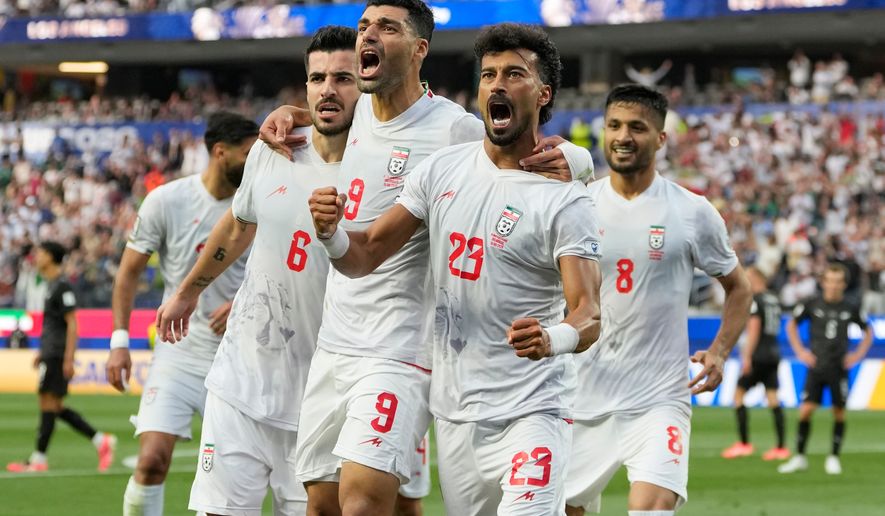 Iran's Ramin Rezaeian (23) celebrates with his teammates after scoring a goal during the World Cup Group G soccer match between Iran and New Zealand in Inglewood, Calif., near Los Angeles, Monday, June 15, 2026. (AP Photo/Andre Penner)