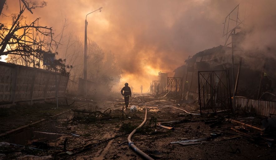 Firefighters try to put out a fire at a city marketplace following a Russian missile and drone attack in Kyiv, Ukraine, Monday, June 15, 2026.(AP Photo/Dan Bashakov)