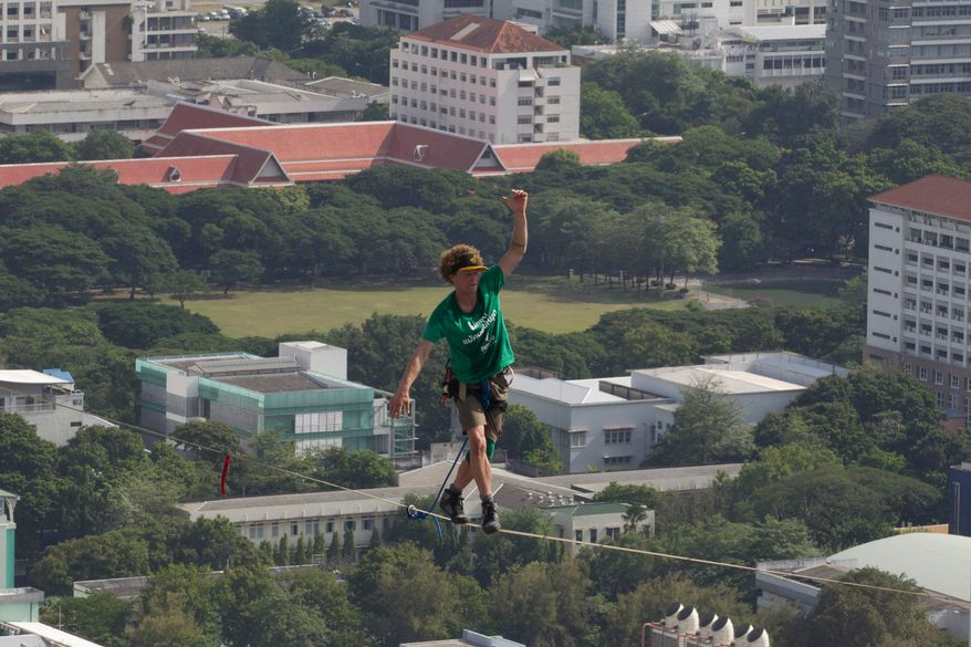 U.S. slackliner Andy Lewis of Calif. balances on a slackline in Bangkok, Thailand, July 23, 2014. (AP Photo/Sakchai Lalit, File)