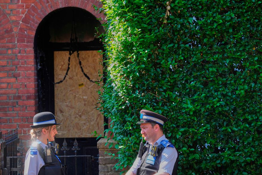 FILE - Police Community Support Officers stand near the fire damage in the doorway of a house belonging to British Prime Minister Keir Starmer in Kentish Town, London, May 13, 2025. (AP Photo/Kirsty Wigglesworth, File)
