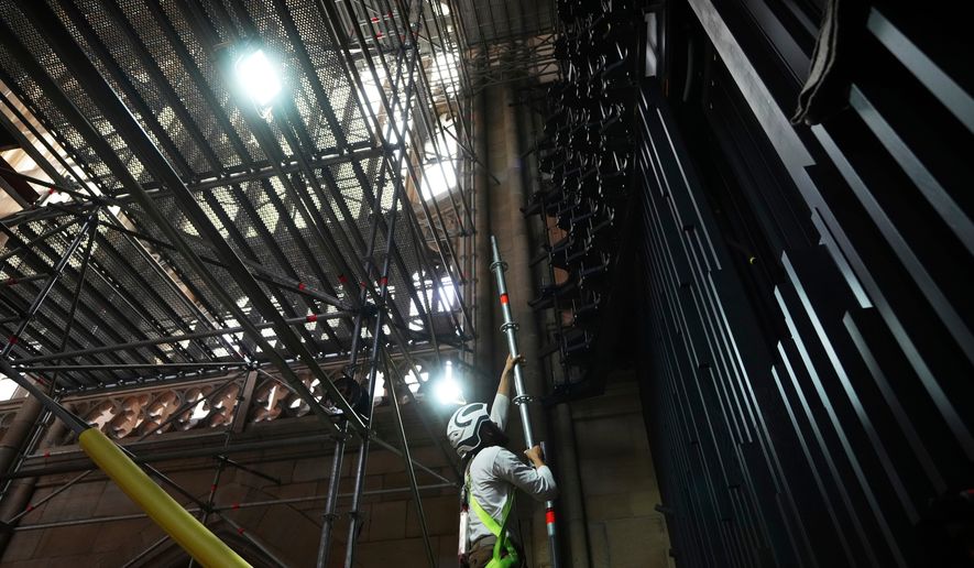 A worker adjusts scaffolding during the installation of a new organ at Prague's St. Vitus Cathedral that is coming to its final stages in Prague, Czech Republic, Tuesday, July 22, 2025. (AP Photo/Petr David Josek, File)