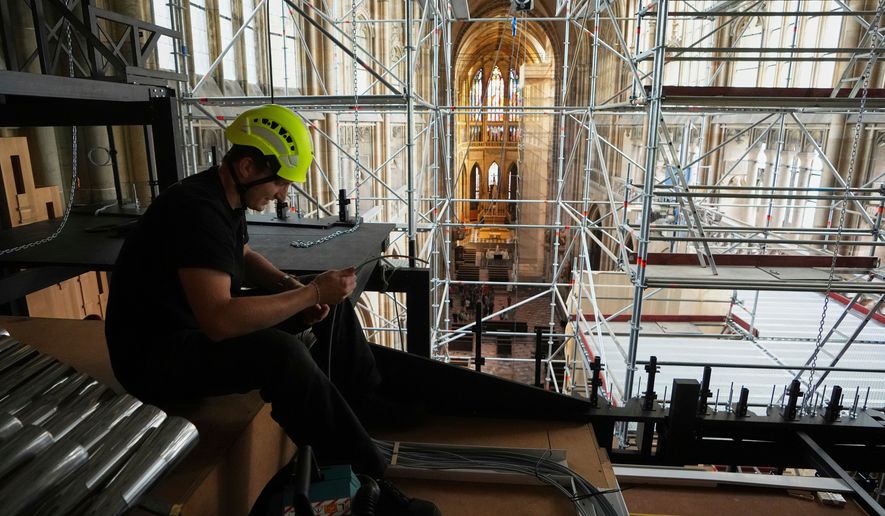 A worker adjusts cables during the installation of a new organ at Prague's St. Vitus Cathedral that is coming to its final stages in Prague, Czech Republic, Tuesday, July 22, 2025. (AP Photo/Petr David Josek, File)