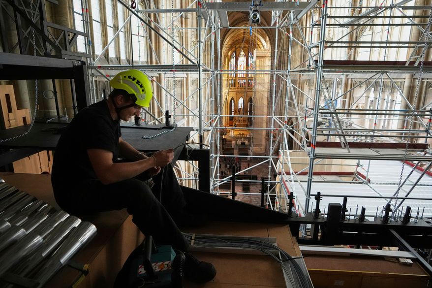 A worker adjusts cables during the installation of a new organ at Prague's St. Vitus Cathedral that is coming to its final stages in Prague, Czech Republic, Tuesday, July 22, 2025. (AP Photo/Petr David Josek, File)