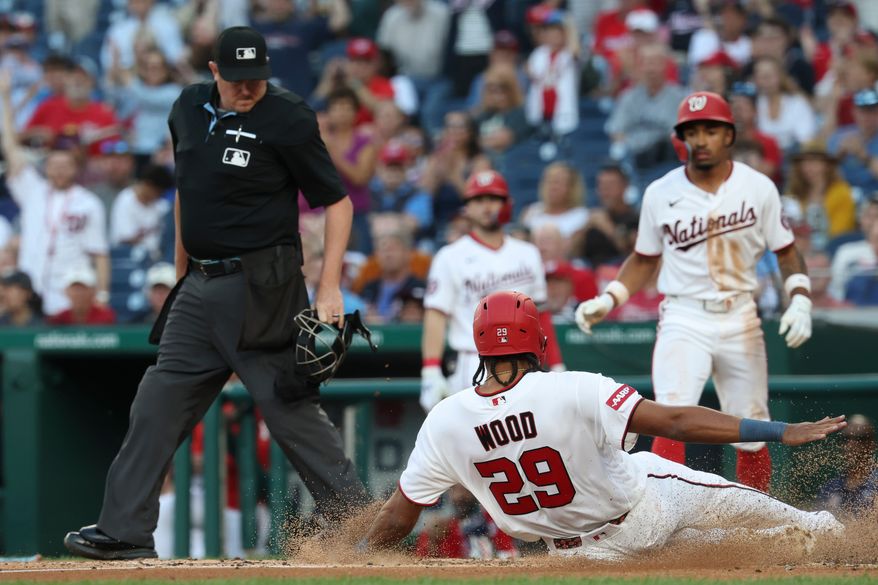 Washington Nationals' James Wood (29) slides into home plate and scores on single hit by Curtis Mead off Kansas City Royals pitcher Mitch Spence during the third inning of a baseball game, Monday, June 15, 2026, in Washington. (AP Photo/Terrance Williams)