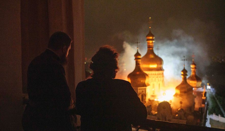 Bishop Avraamiy, right, of the Kyiv-Pechersk Lavra of the Orthodox Church of Ukraine, looks at the burning Dormition Cathedral of Kyiv-Pechersk Lavra, also known as the Monastery of the Caves, during a Russian strike on Kyiv, Ukraine, on Monday, June 15, 2026. (AP Photo/Evgeniy Maloletka)
