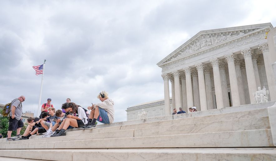Visitors sit on the steps of the U.S. Supreme Court, Monday, June 8, 2026, in Washington. (AP Photo/Mariam Zuhaib)