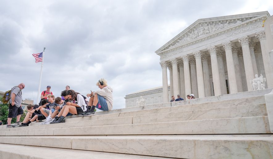 Visitors sit on the steps of the U.S. Supreme Court, Monday, June 8, 2026, in Washington. (AP Photo/Mariam Zuhaib)