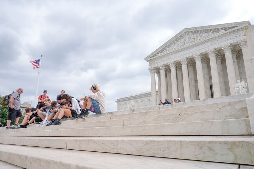 Visitors sit on the steps of the U.S. Supreme Court, Monday, June 8, 2026, in Washington. (AP Photo/Mariam Zuhaib)