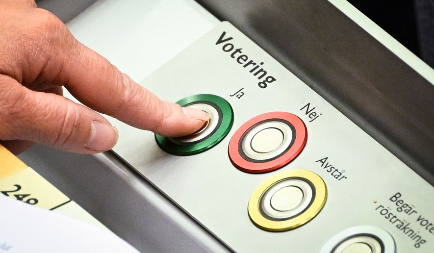 A member of Swedish parliament (Riksdagen) votes on new justice legislation in Stockholm, Monday, June 15, 2026. (Fredrik Sandberg/TT News Agency via AP)