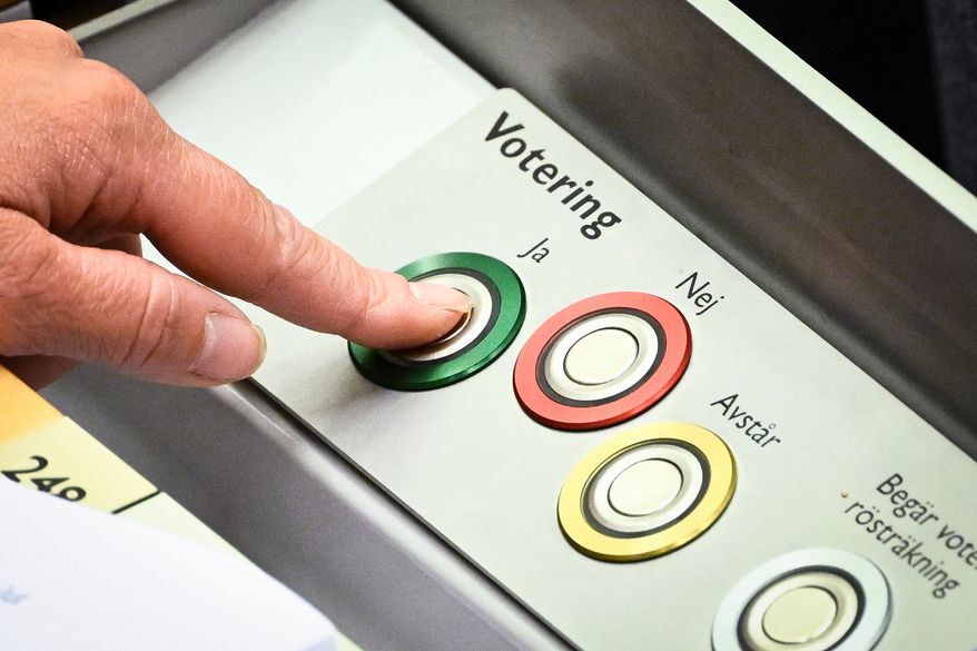 A member of Swedish parliament (Riksdagen) votes on new justice legislation in Stockholm, Monday, June 15, 2026. (Fredrik Sandberg/TT News Agency via AP)