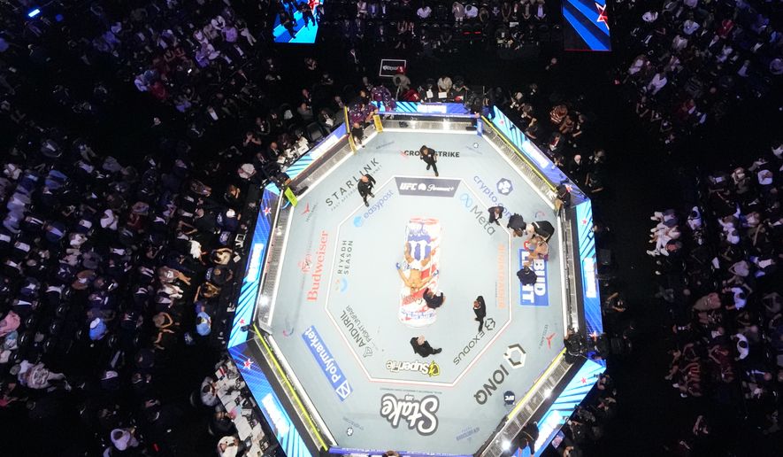Alex Pereira, far right, is attended to, as Ciryl Gane lays in the center of the ring during UFC Freedom 250 on the South Lawn of the White House, Monday, June 15, 2026, in Washington. (AP Photo/Alex Brandon, Pool)