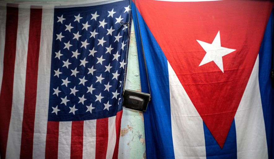 A U.S. and Cuban flag hangs on a wall in Havana, Cuba, Monday, Jan 11, 2021. (AP Photo/Ramon Espinosa, File)