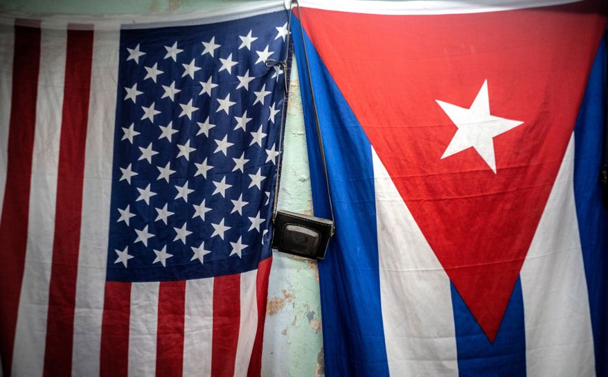 A U.S. and Cuban flag hangs on a wall in Havana, Cuba, Monday, Jan 11, 2021. (AP Photo/Ramon Espinosa, File)