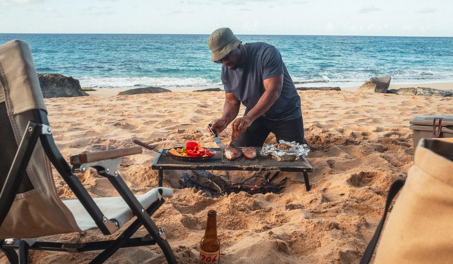 Rashad Frazier prepares food on a beach on Manatí, Puerto Rico. on Jan. 20, 2025. (Alex Forestier via AP)