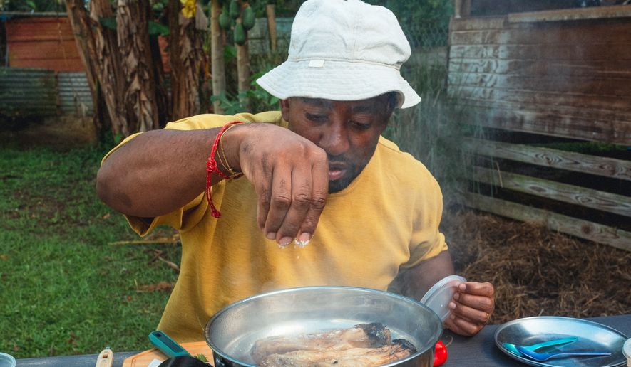 Rashad Frazier prepares food outdoors in Lava Lands, Ore., on Aug. 7, 2024. (Alex Forestier via AP)