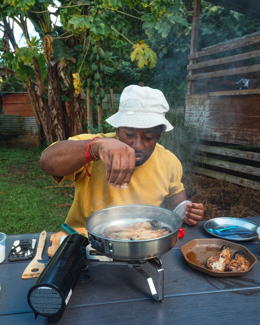 Rashad Frazier prepares food outdoors in Lava Lands, Ore., on Aug. 7, 2024. (Alex Forestier via AP)