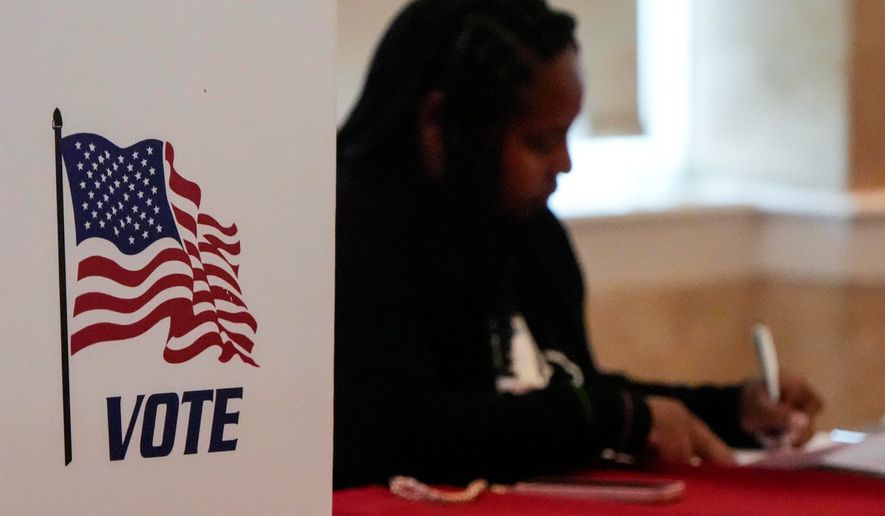 A Fulton County staff member works as people vote in a runoff election, Tuesday, June 16, 2026, in Atlanta. (AP Photo/Mike Stewart)