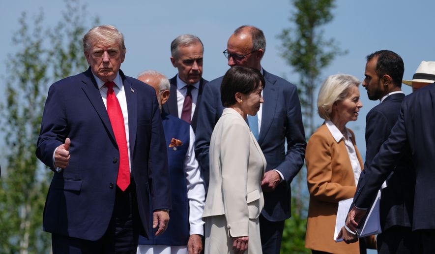 U.S. President Donald Trump, left, gestures prior to a group photo of G7 leaders and invited nations during the G7 summit in Evian-les-Bains, France, Tuesday, June 16, 2026. (AP Photo/Thibault Camus)