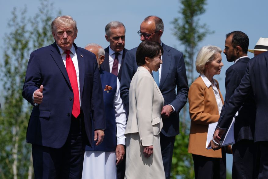 U.S. President Donald Trump, left, gestures prior to a group photo of G7 leaders and invited nations during the G7 summit in Evian-les-Bains, France, Tuesday, June 16, 2026. (AP Photo/Thibault Camus)