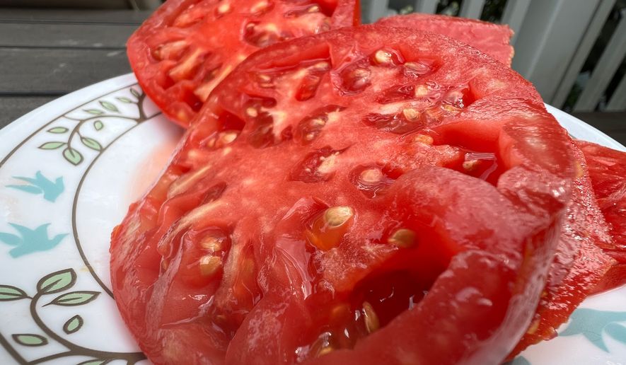 A halved Brandywine tomato appears at a home on Long Island, N.Y. on July 31, 2024. (Jessica Damiano via AP)