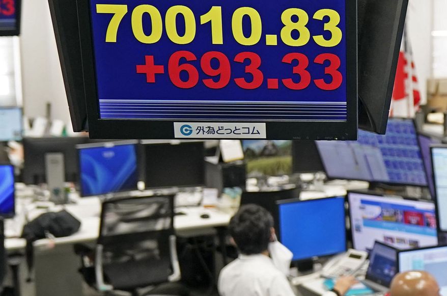 Employee of a foreign exchange dealing company work under an electronic board showing the stock index of Japan's Nikkei 225, in Tokyo Tuesday, Jun 16, 2026. (Kyodo News via AP)