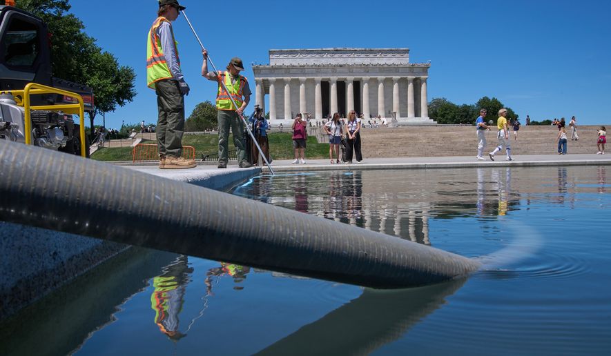 Members of the National Park Service work to clean the Lincoln Memorial Reflecting Pool of algae, Tuesday, June 16, 2026, in Washington. (AP Photo/Jacquelyn Martin)
