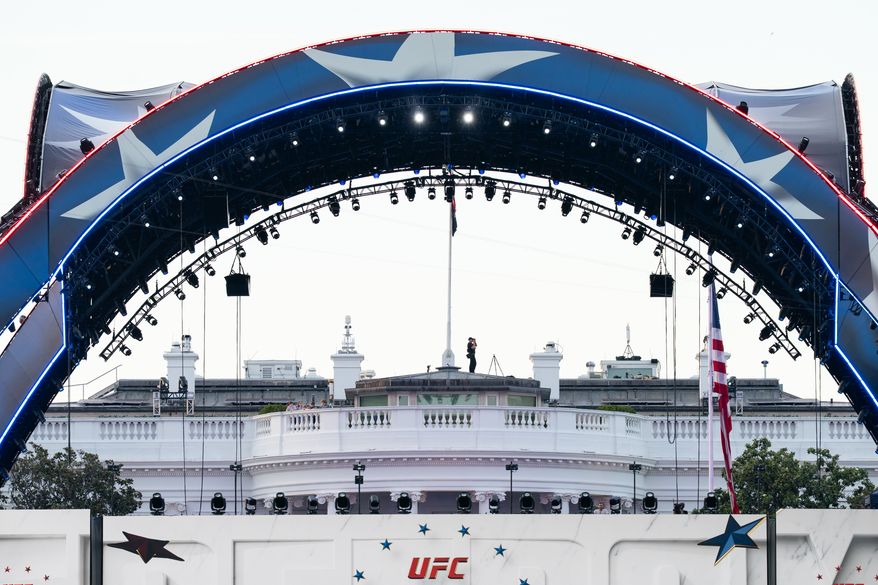Security at the White House looks through a pair of binoculars during the UFC Fan Fest on the White House Ellipse ahead of Sunday's fight on the South Lawn, June 13, 2026, in Washington. (AP Photo/Allison Robbert, File)