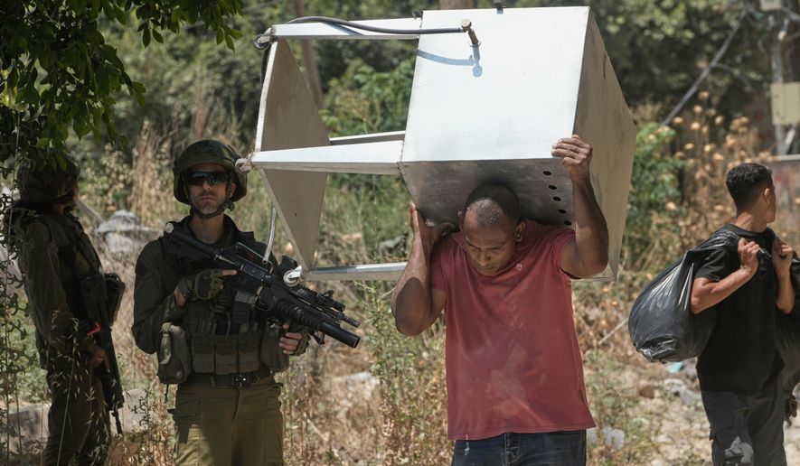 Palestinians collect their belongings from their evacuated homes after the Israeli army issued a number of short term access permits for residents of the occupied West Bank refugee camp of Tulkarem, Wednesday, June 17, 2026. (AP Photo/Majdi Mohammed)