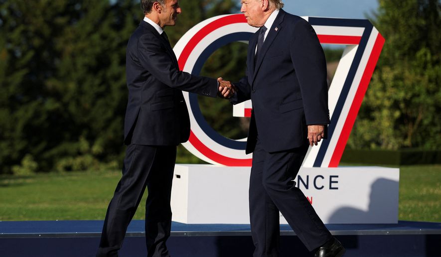 French President Emmanuel Macron greets President Donald Trump, right, during the official arrivals ceremony for the G7 summit in Evian-les-Bains, France, Monday, June 15, 2026. (Isabel Infantes, Pool Photo via AP)