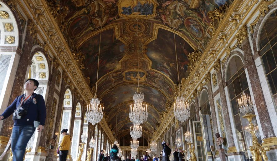 FILE - Visitors walk inside the Hall of Mirrors in the Versailles castle, on Nov. 17, 2015 in Versailles, west of Paris. (AP Photo/Amr Nabil, File)