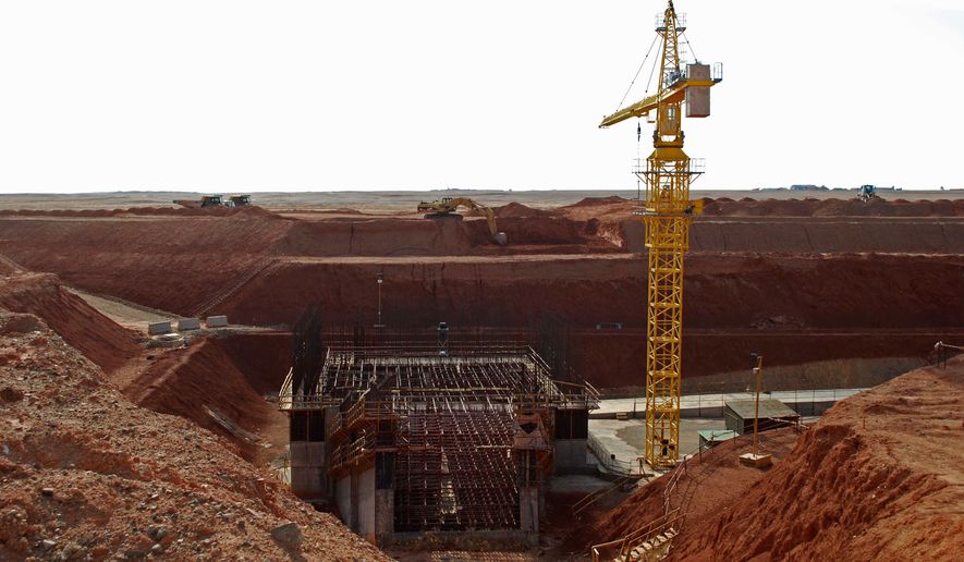 FILE - A crane hovers above the site of a new shaft under construction at the Oyu Tolgoi mine site in Khanbogd village, Umnugobi province, Mongolia, Nov. 7, 2009. (AP Photo/Ganbat Namjilsangarav, File)
