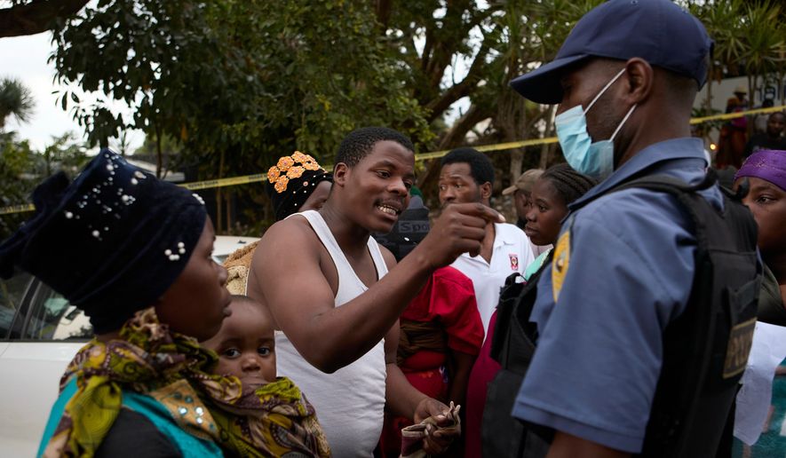 Malawian man talks to a police officer after clashes with police at a deportation site, in Durban, South Africa, Wednesday, June 17, 2026. (AP Photo)