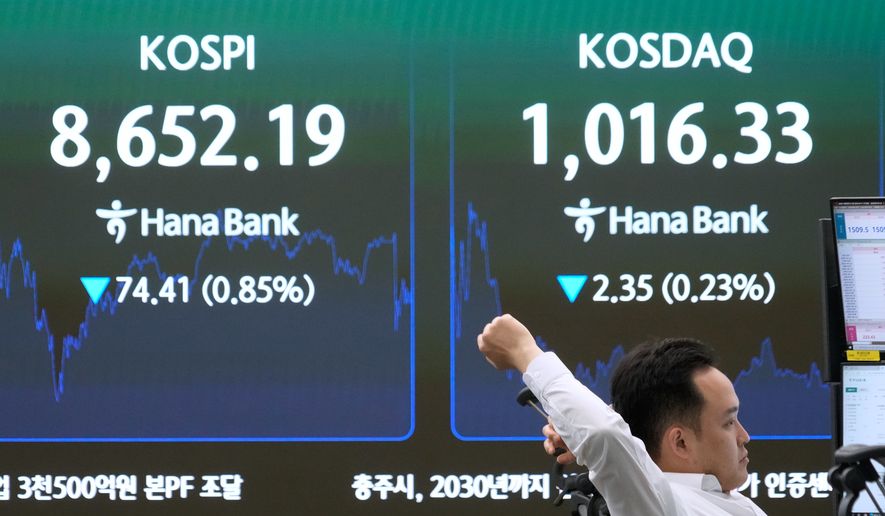 A currency trader stretches near a screen showing the Korea Composite Stock Price Index (KOSPI) at the foreign exchange dealing room of the Hana Bank headquarters in Seoul, South Korea, Wednesday, June 17, 2026. (AP Photo/Ahn Young-joon)