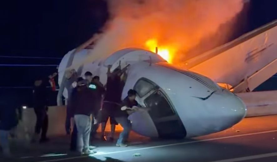 People attempt to pull passengers out of a plane after it crashed on a highway Tuesday, June 16, 2026, in Laredo, Texas. (Zayra Garza via AP)