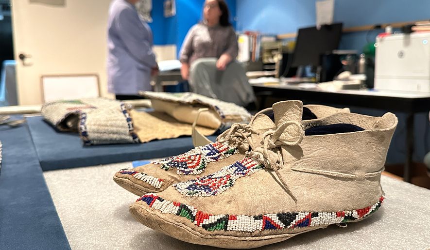 Decades-old moccasins from Taos Pueblo that feature red, white and blue beads are prepared for display as part of the "Stars, Stripes and First Americans" exhibition at the Museum of Indian Arts and Culture in Santa Fe, N.M., on Monday, May 11, 2026. (AP Photo/Susan Montoya Bryan)