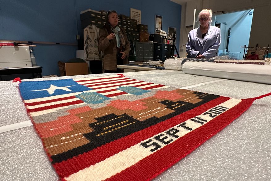 Museum executive director Danyelle Means, left, and head of curatorial affairs Elisa Phelps discuss a weaving by Navajo artist Pauline Thomas as it's prepared for display at the Museum of Indian Arts and Culture in Santa Fe, N.M., on Monday, May 11, 2026. (AP Photo/Susan Montoya Bryan)