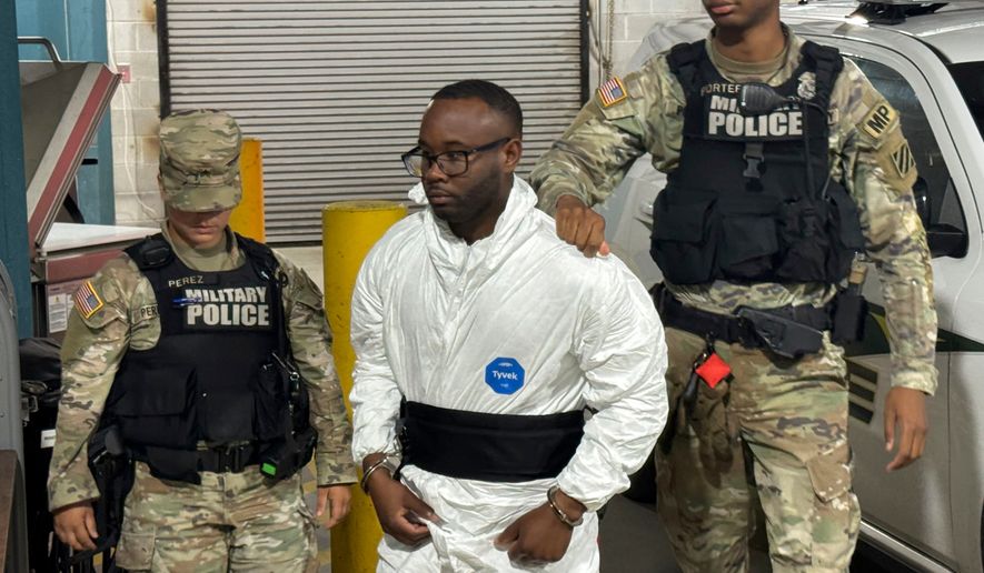 FILE - Sgt. Quornelius Radford, center, is escorted by military police into a booking room at the Liberty County Jail in Hinesville, Ga., Aug. 6, 2025. (AP Photo/Lewis M. Levine, File)