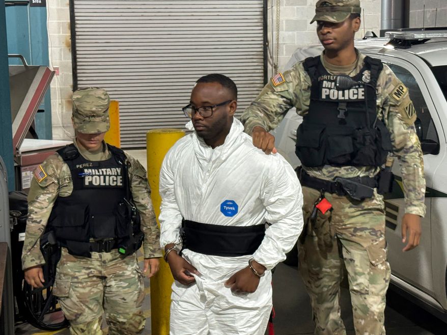 FILE - Sgt. Quornelius Radford, center, is escorted by military police into a booking room at the Liberty County Jail in Hinesville, Ga., Aug. 6, 2025. (AP Photo/Lewis M. Levine, File)