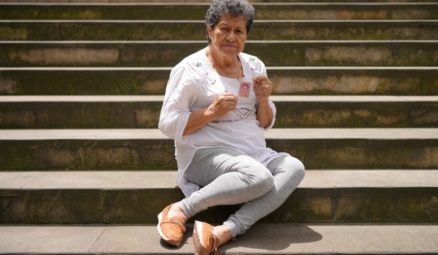 Blanca Nubia Monroy poses with a photograph of her son, Julian Oviedo, who disappeared in 2008 and whose body was found months later in a clandestine grave, in Bogota, Colombia, , June 1, 2026. (AP Photo/Matias Delacroix)