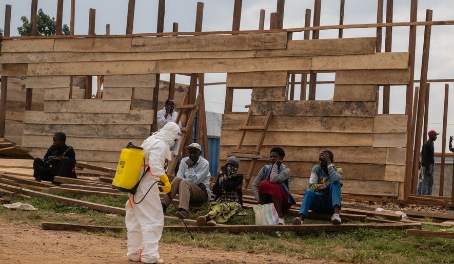 A health worker disinfects the area around a treatment center under construction at the General Hospital in Bunia, Congo, Monday, June 15, 2026. (AP Photo/Moses Sawasawa)