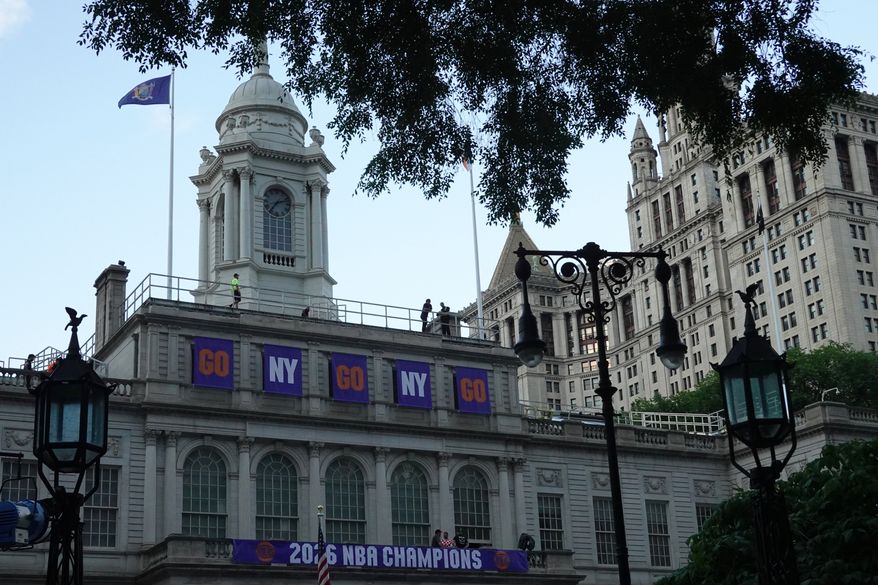 Banners hang above City Hall as preparations take place, Wednesday, June 17, 2026, in New York, ahead of the New York Knicks' NBA championship ticker-tape parade. (AP Photo/Alyssa Goodman)