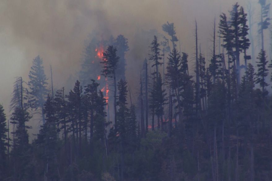 FILE - Smoke rises from a fire after a small medical plane crashed in a mountain range outside Ruidoso, N.M., on May 14, 2026. (KOAT via AP, File)