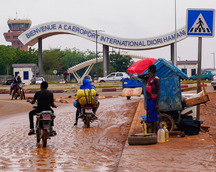 Motorcyclists ride by the entrance of the airport in Niamey, Niger, Aug. 8, 2023. (AP Photo/Sam Mednick, File)