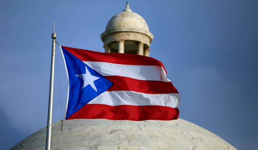 FILE - A Puerto Rican national flag flies in front of the Capitol building in San Juan, Puerto Rico, July 29, 2015. (AP Photo/Ricardo Arduengo, File)