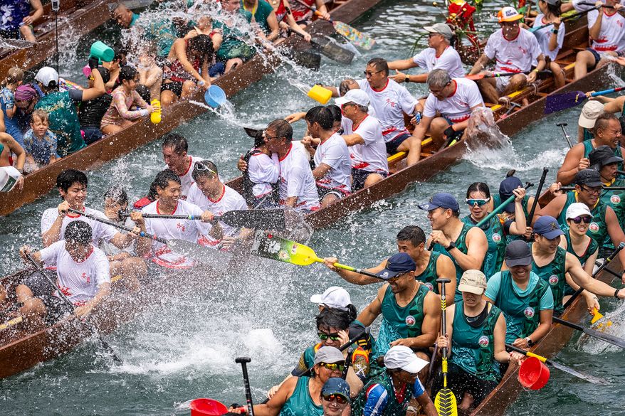 Competitors splash water on each other during the Aberdeen Dragon Boat Race to celebrate the Dragon Boat Festival in Hong Kong, Friday, June 19, 2026. (AP Photo/Chan Long Hei)