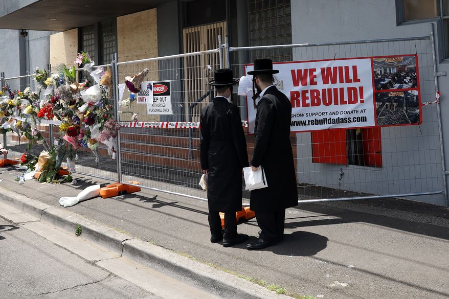 People gather outside the Adass Israel Synagogue, Dec. 9, 2024, after a firebombing in Melbourne, Australia. (Con Chronis/AAP Image via AP)