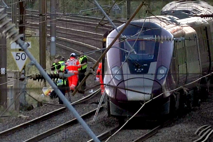 Emergency personnel work on a train on the tracks outside Bedford, England, after a train from Corby to London St. Pancras and another from Nottingham to London St. Pancras, collided on Friday June 19, 2026. (Jamie Lashmar/PA via AP)