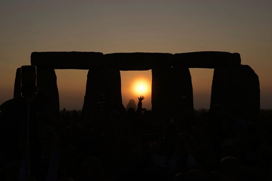 FILE - Revelers gather at the ancient stone circle Stonehenge to celebrate the Summer Solstice, the longest day of the year, near Salisbury, England, Wednesday, June 21, 2023. (AP Photo/Kin Cheung, File)