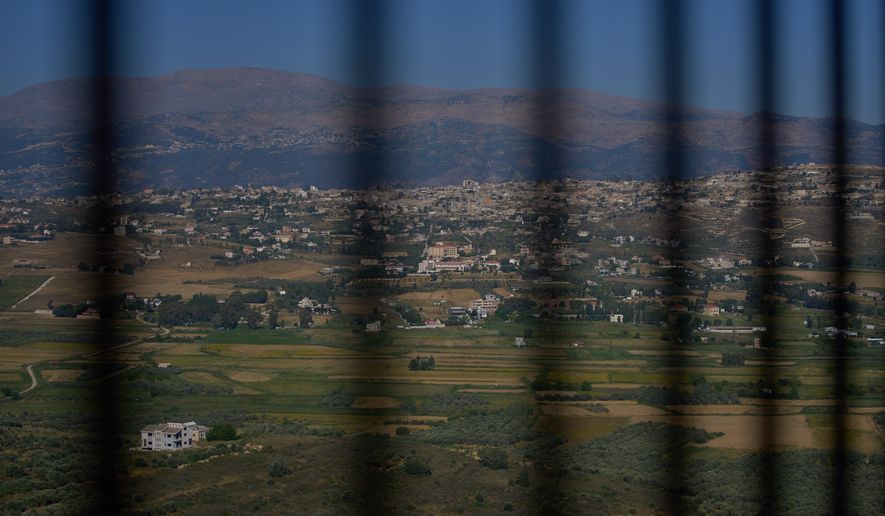 The southern town of Khiam, Lebanon, is seen through a fence near the Lebanon-Israel border, Wednesday, June 10, 2026. (AP Photo/Hassan Ammar)