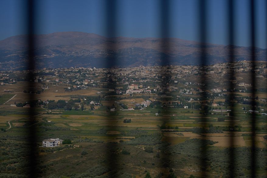 The southern town of Khiam, Lebanon, is seen through a fence near the Lebanon-Israel border, Wednesday, June 10, 2026. (AP Photo/Hassan Ammar)